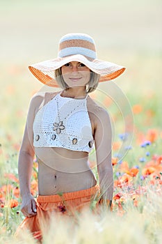 Young beautiful woman on golden wheat field in summer