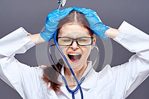 Young beautiful woman on a gray background, cry, doctor, medicine