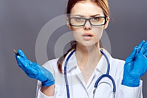 Young beautiful woman on a gray background in rubber medical gloves, medicine, doctor, doctor