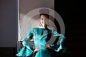 Young and beautiful woman with green frilly dress and dancing flamenco is on the stairs of plaza de espana in seville, andalusia. photo