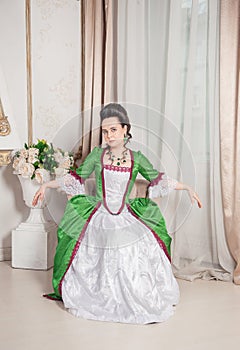 Young beautiful woman in green rococo style medieval dress