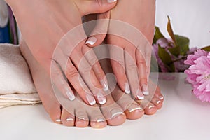 Elegant French Manicure and Pedicure: Beautiful Female Hands and Feet in Beauty Salon