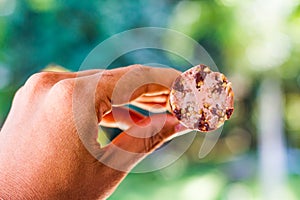 Young beautiful woman hands holding melting ice cream in hands on summer light nature background