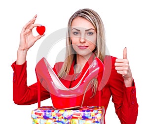 Young beautiful woman happy to receive red high heels shoes as a present and showing thumb up gesture