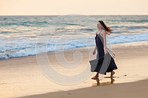 Young beautiful woman has fun at the ocean in summertime