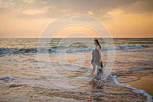 Young beautiful woman has fun at the ocean in summertime