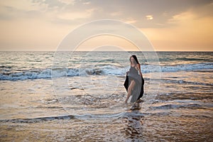 Young beautiful woman has fun at the ocean in summertime