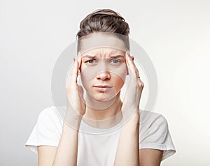 Young beautiful woman has headache, isolated on gray background