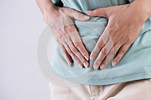 Young beautiful woman having painful stomachache. Chronic gastritis. Abdomen bloating concept photo