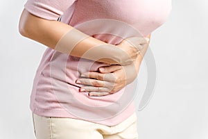 Young beautiful woman having painful stomachache on white background.Chronic gastritis. Abdomen bloating concept photo