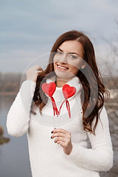 Young beautiful woman with hearts in hands