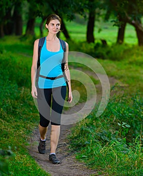 Young Beautiful Woman Hiking in the Green Summer Forest