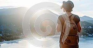 Young beautiful woman hipster traveler looking at sunset and beautiful seascape with a lookout point. Freedom, travel, vacation