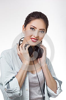 Young beautiful woman holding big headphones isolated white background