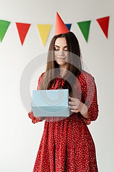 young beautiful woman holding a box with a gift in her hands. Holiday birthday.