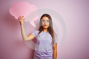 Young beautiful woman holding cloud speech bubble over isolated pink background with a confident expression on smart face thinking