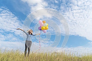 Young beautiful woman holding colorful air balloons in the park.  Relaxation on international womans day