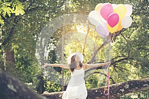 Young beautiful woman holding colorful air balloons in the park.  Relaxation on international womens day