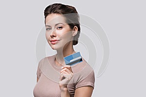 Young beautiful woman holding credit card isolated on white background. Online shopping, e-commerce, internet banking concept