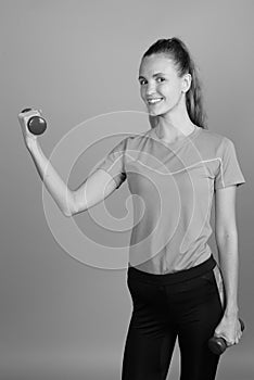 Young beautiful woman holding dumbbells ready for exercise