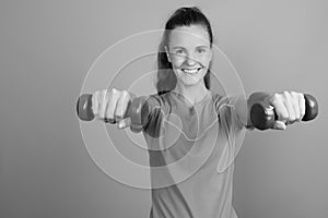 Young beautiful woman holding dumbbells ready for exercise