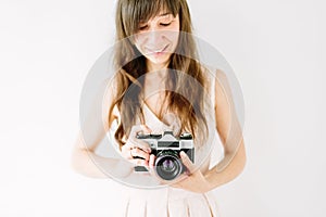 Young beautiful woman holding in hands old vintage film camera. Girl wedding photographer