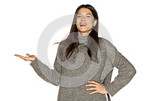 Young beautiful woman holding imaginary object on her hand