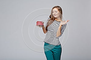 Young beautiful woman holding small red box. Studio portrait on