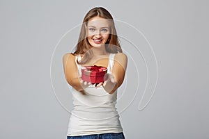 Young beautiful woman holding small red box. Studio portrait on