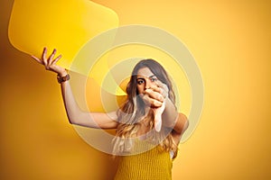 Young beautiful woman holding speech bubble over yellow isolated background with angry face, negative sign showing dislike with