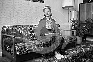 Young beautiful woman in the image of the famous artist Frida Kahlo posing indoors. Black and white photography