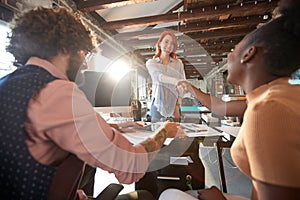 A young beautiful woman is introducing herself to colleagues in the office at her new job