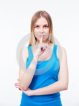 Young beautiful woman keeping finger on her lips photo