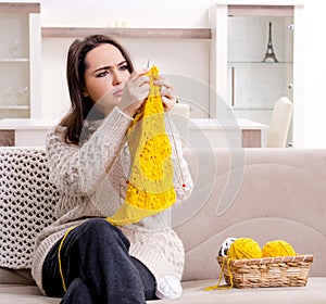 Young beautiful woman knitting at home