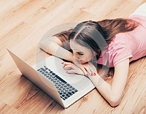 Young beautiful woman with laptop notebook on floor home surfing internet