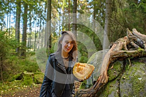 Young beautiful woman in leather jacket with pumpkin in a forest