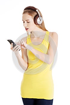 Young beautiful woman listening to music with headphones.