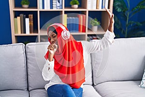 Young beautiful woman listening to music singing song at home