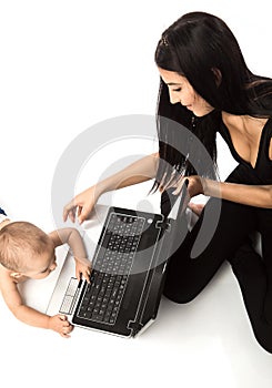 Young beautiful woman and little boy playing with laptop