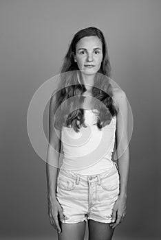 Young beautiful woman with long blond hair against gray background