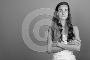 Young beautiful woman with long blond hair against gray background