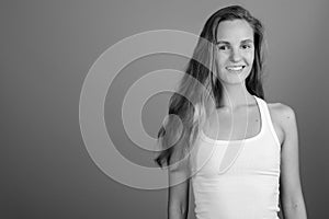 Young beautiful woman with long blond hair against gray background