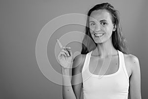 Young beautiful woman with long blond hair against gray background