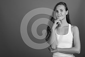 Young beautiful woman with long blond hair against gray background