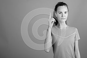 Young beautiful woman with long blond hair ready for gym against gray background