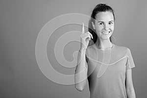 Young beautiful woman with long blond hair ready for gym against gray background