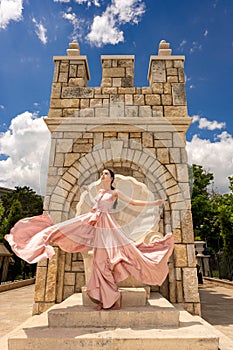 Young beautiful woman with long dress modelling on a sunny day in summer time