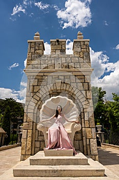 Young beautiful woman with long dress modelling on a sunny day in summer time