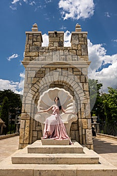 Young beautiful woman with long dress modelling on a sunny day in summer time