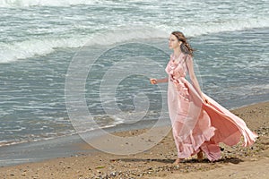 Young beautiful woman with long dress ,romantic mood on the beach with waves, Black sea side  Bulgaria